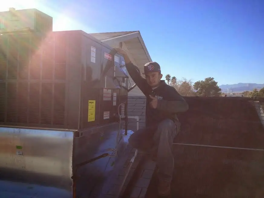 HVAC technician performing Air Duct Cleaning on a rooftop unit in Brownfields